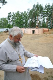 Отец-благочинный Иоанн Монаршек изучает проект Александро-Невского храма Красноармейска